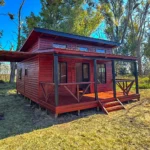 Fachada de la cabaña Vistas de 44m² con acabados en madera y aberturas de aluminio