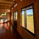 Interior sala de estar y cocina de cabaña de madera Vistas de 44m²